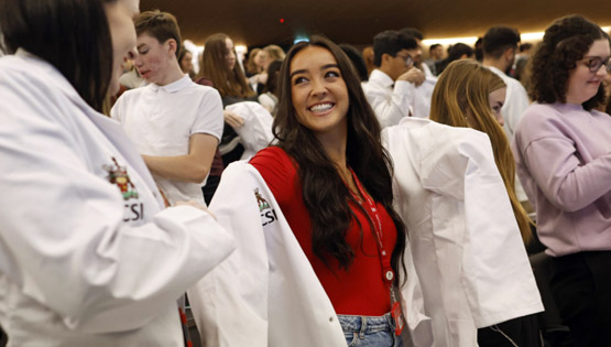 Smiling students at a white coat ceremony