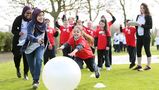 Students and children play together in a park