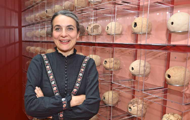 Artist poses in front of her artwork