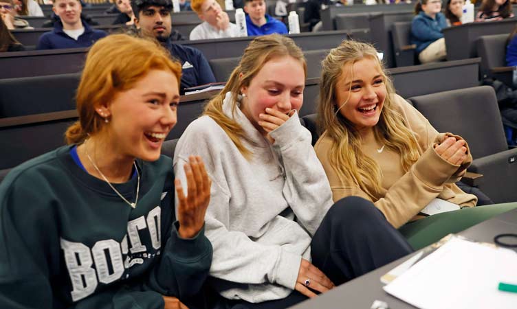 Three schoolgirls laugh during presentation