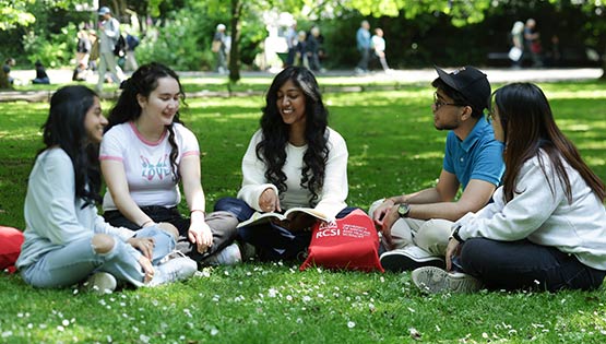 Group of RCSI students sitting in a cicle on the grass in St Stephens Green