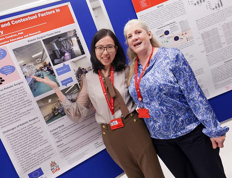 Two people with a poster explaining a medical project.