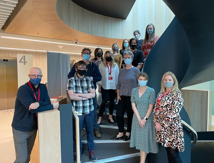 The project group posing on a staircase.