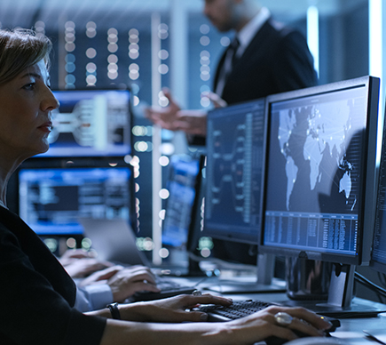 An IT professional working at a desktop computer.