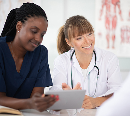 Two medical professionals working at a tablet device.