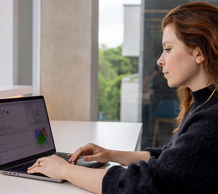 A medical scientist working at a laptop.