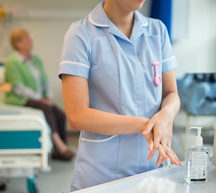 A nurse sanitising her hands.