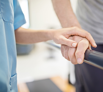 A nurse assisting a patient who is using a handrail.