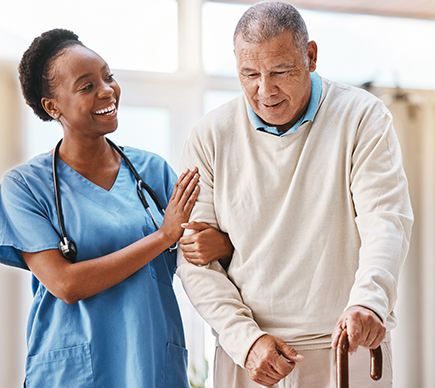 An elderly man with a walking cane being assisted by a doctor.