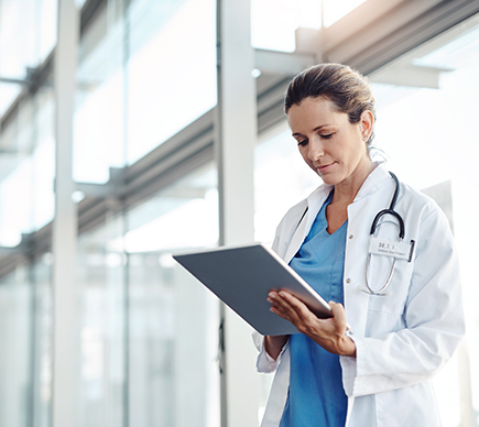 A female doctor working on a tablet device.