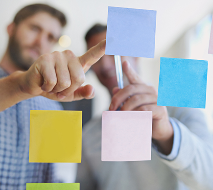 A team of healthcare professionals viewing Post-It notes.