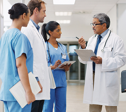 A medical team conferring in a hospital corridor.