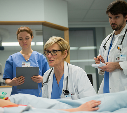 A female physician associate and colleagues in a medical environment.