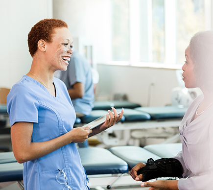 A female nurse smiling with a patient.