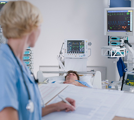 A nurse at a patient's bedside.