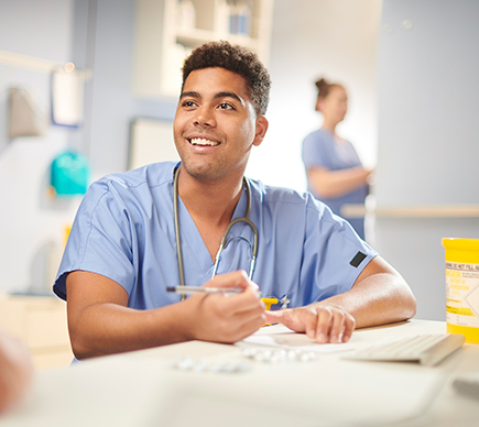 A male medical professional working on a patient's file.