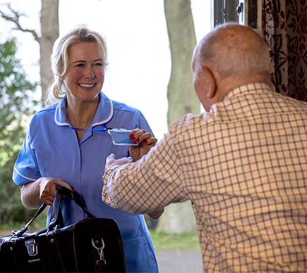 A nurse shows her ID to an elderly patient.