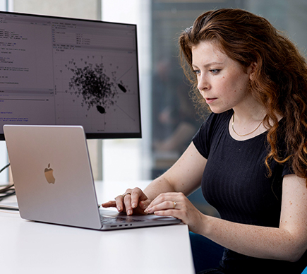 A medical scientist working at a laptop.