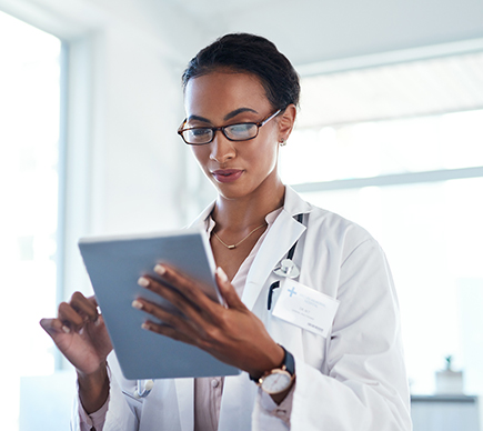 A medical professional working on a tablet device.